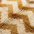 Gros plan sur tapis berbère beige et marron montrant texture épaisse en laine douce et moelleuse