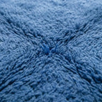 Gros plan tapis berbère bleu texture laine épaisse moelleuse artisanat marocain haut de gamme