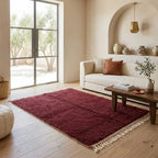 Tapis berbère bordeaux uni dans salon lumineux style minimaliste chic avec mobilier naturel