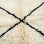 Gros plan tapis berbère crème avec motifs lignes noires texture laine épaisse artisanat marocain