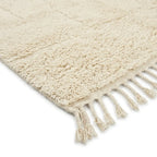 Détail tapis berbère crème uni avec franges finition artisanale marocaine design épuré haut de gamme
