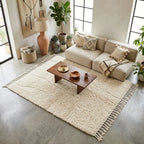 Tapis berbère crème uni dans salon moderne ambiance naturelle minimaliste avec mobilier en bois