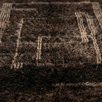 Gros plan sur tapis berbère marron avec motifs géométriques tissés, finition artisanale et qualité premium