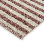 Détail finition tapis berbère avec franges et rayures rose et écru, design artisanal et tendance pour intérieur cosy