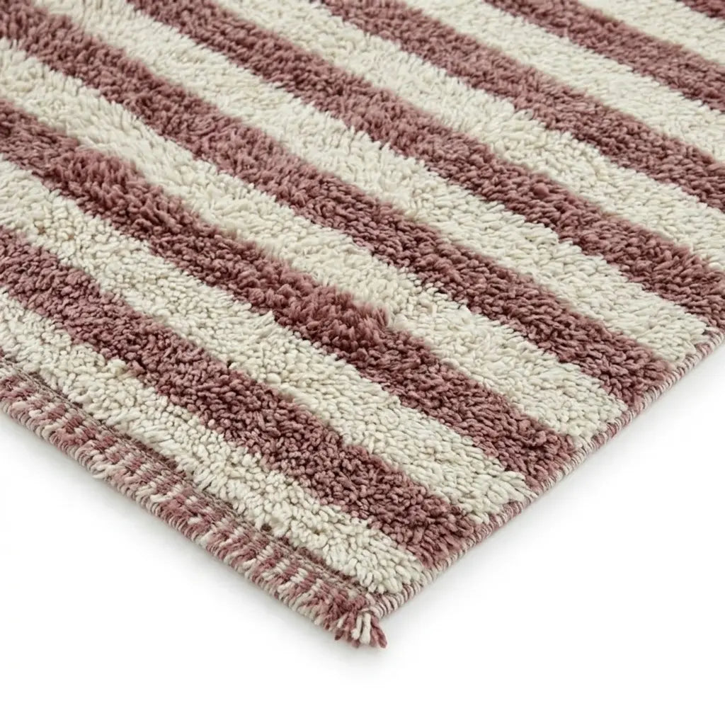 Détail finition tapis berbère avec franges et rayures rose et écru, design artisanal et tendance pour intérieur cosy