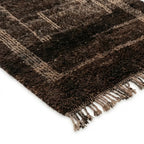 Détail tapis berbère marron avec franges tressées et motifs géométriques, finition artisanale haut de gamme