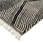 Détail tapis berbère avec franges et rayures noir et blanc, finition artisanale et qualité premium