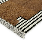 détail tapis berbère marron avec franges et rayures noir blanc, tissage artisanal en laine pour décoration authentique