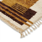 Détail des franges et des finitions d’un tapis berbère ocre à motifs géométriques