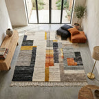 Tapis berbère géométrique multicolore dans un intérieur minimaliste avec mobilier moderne
