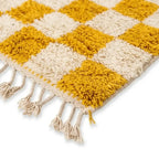 Détail tapis berbère jaune à carreaux avec franges finition artisanale marocaine haut de gamme