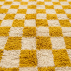 Gros plan tapis berbère jaune et crème à carreaux texture laine épaisse moelleuse design artisanal