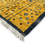 Détail tapis berbère jaune avec franges et bordures noires fabrication artisanale marocaine haut de gamme