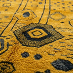 Gros plan sur tapis berbère jaune avec motifs abstraits noirs style marocain design artisanal unique