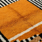Gros plan tapis berbère jaune moutarde en laine épaisse texture moelleuse artisanat marocain haut de gamme