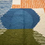 Gros plan tapis berbère multicolore avec motifs géométriques bleu vert et orange design contemporain marocain