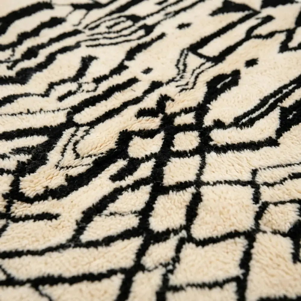 Gros plan tapis berbère noir et blanc motifs abstraits en laine épaisse texture artisanale marocaine