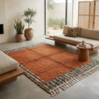Tapis berbère ocre avec bordure noir et beige dans un salon lumineux, style bohème chic et ambiance chaleureuse