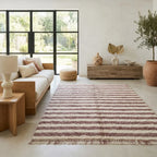 Tapis berbère à rayures rose et beige dans un salon moderne, style bohème chic, idéal pour décoration chaleureuse