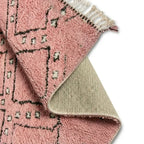 Détail du dessous antidérapant d’un tapis berbère rose avec motifs géométriques, assurant stabilité et durabilité pour un usage quotidien