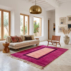 Tapis berbère rose fuchsia avec centre pêche et bordures contrastées, idéal pour un salon lumineux au style bohème chic