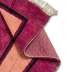 Détail du dessous antidérapant d’un tapis berbère rose fuchsia avec centre pêche, assurant stabilité et maintien optimal sur tous types de sols
