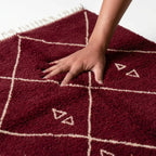 Tapis berbère rouge avec motifs géométriques blancs, texture moelleuse en laine pour un confort optimal et une décoration chaleureuse