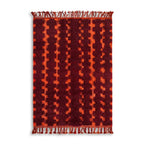 Tapis berbère rouge avec motifs géométriques vintage, design artisanal chaleureux pour salon bohème et ambiance cosy