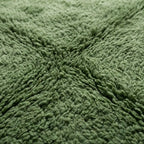 Gros plan sur un tapis berbère shaggy vert doux et épais, texture moelleuse idéale pour décoration intérieure moderne et confort maison