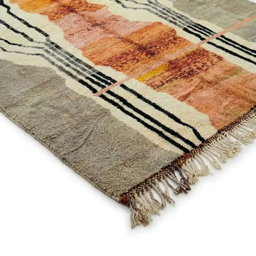 Détail tapis berbère terracotta avec franges et finitions artisanales motifs noirs et crème design marocain