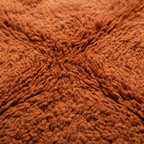 Gros plan texture tapis berbère terracotta en laine épaisse design artisanal marocain premium