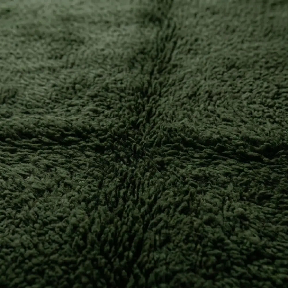 gros plan sur texture dense du tapis berbère vert foncé, fibres épaisses et finition haut de gamme pour intérieur cosy