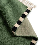 tapis berbère vert à poils longs avec motifs géométriques noirs et blancs et franges décoratives, tapis marocain design moderne pour salon cosy