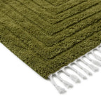 coin de tapis berbère vert olive avec franges blanches et motif texturé, parfait pour décoration intérieure bohème chic